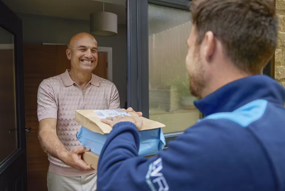 Delivery person handing package to customer